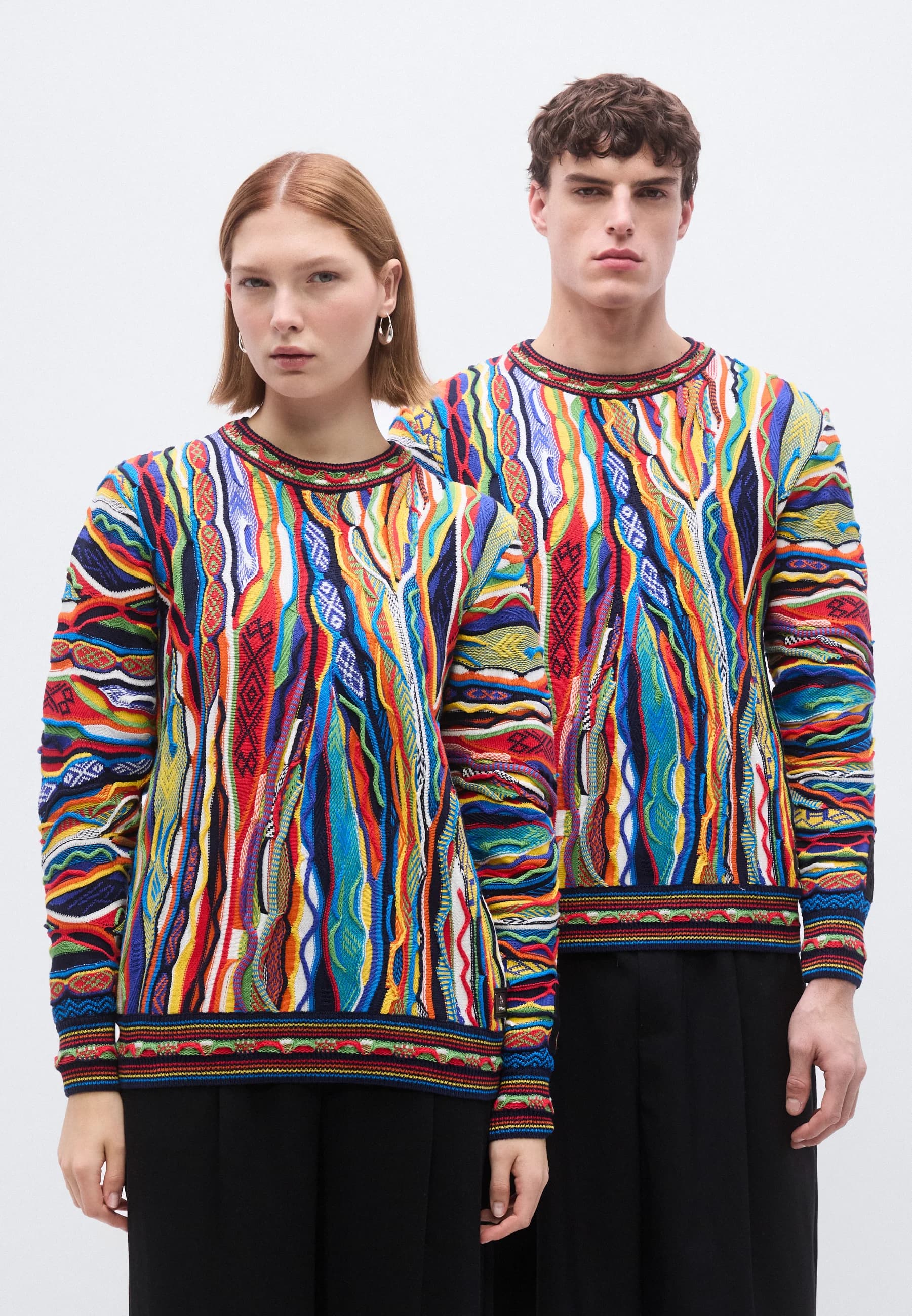 A pair of models presenting the Carlo Colucci 3D unisex sweater.